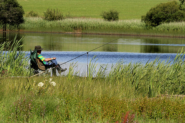 A man fishing next to a river in Tipperary Ireland